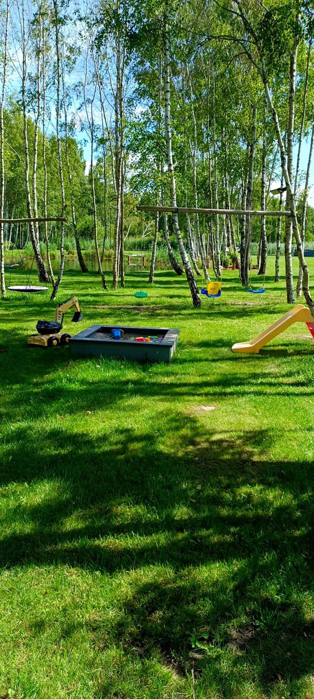 Plac zabaw nad stawem — piaskownica, huśtawki i zjeżdżalnia